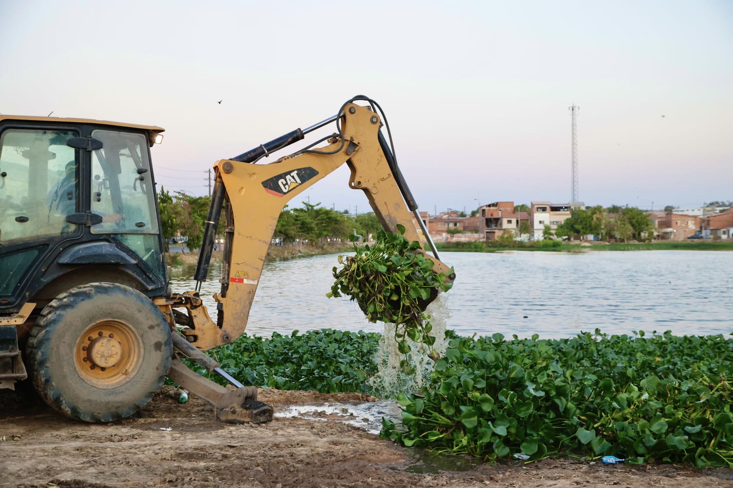 máquina pesada fazendo a limpeza de uma lagoa